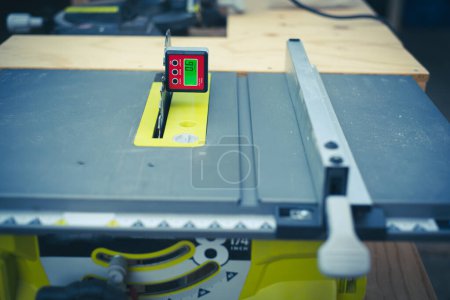 Photo for Brand-new table saw with digital level box inclinometer showing 0-degree angle attaches to steel blade and aluminum fence. Protractor bevel gauge for absolute measurements woodworking carpentry - Royalty Free Image