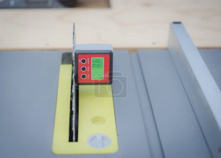 Photo for 9-degree angle level calibration on digital level box inclinometer attaches to steel blade of brand-new table saw on magnetic base. Protractor bevel gauge absolute measurements woodworking carpentry - Royalty Free Image
