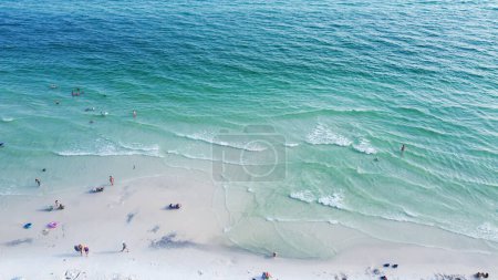 Téléchargez les photos : Superbe nuance d'eau turquoise bleue et cristalline de la plage de Santa Rosa, rivage sablonneux blanc brillant avec des gens nageant, ambiance relaxante et décontractée charmant comté de Walton, Floride, États-Unis. Aérien - en image libre de droit