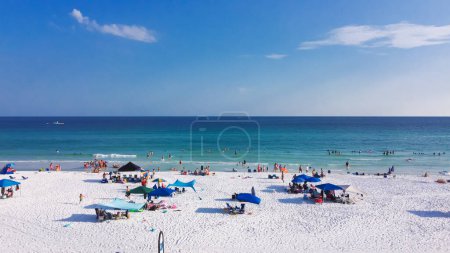 Téléchargez les photos : Parapluie de plage coloré et baignade des gens, détente décontractée sur les plages de sable blanc sucre, limpide cristal propre magnifique nuance d'eau turquoise bleue Destin, South Walton, Floride, États-Unis. Vue aérienne - en image libre de droit