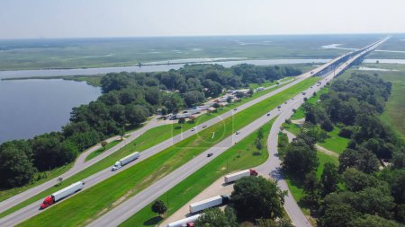 Photo for Jackson County Rest Area West rest area with Pascagoula River bridge, large parking lots semi-trucks, cargo trailers along Interstate 10 (I-10) floodplain in Gautier, Lower Mississippi. Aerial view - Royalty Free Image