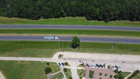 Téléchargez les photos : Entrée de l'aire de repos le long de l'autoroute Interstate 10 (I-10) à Greenwood, Louisiane, États-Unis entourée de pins verts, de cours bien découpées et d'une aire de pique-nique. Arrêt autoroutier moderne aérien, transport - en image libre de droit