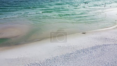 Foto de Vista aérea playa tranquila con jus pocas personas disfrutan de la natación, paseos en bote a lo largo de hermosa arena blanca, agua turquesa, múltiples tonos de olas azules a lo largo de la costa esmeralda, playa Seagrove, Santa Rosa. Estados Unidos - Imagen libre de derechos