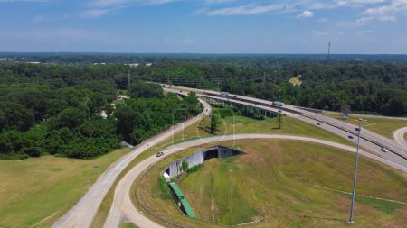 Circular highway exit or ring road with railroad tunnel, large drainage system, overpass, viaduct off highway interstate 20 in Vicksburg, Mississippi. Aerial view beltline loop alternate route ramp