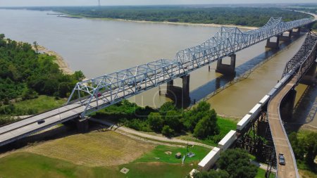 Téléchargez les photos : Vue aérienne Double pont de Vicksburg transportant l'Interstate 20 (I-20), US Route 80 avec des wagons et des trains de marchandises traversant le fleuve Mississippi entre Delta, Louisiane et Vicksburg. Petite ville États-Unis - en image libre de droit
