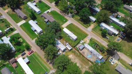 Photo for Close-up aerial low-density housing of mobile manufactured homes on large lot size, well-trimmed lawn, mature trees near Richland Westside Park, suburb of Jackson, Mississippi. Trailer neighborhood - Royalty Free Image