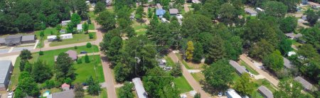 Téléchargez les photos : Panorama logements de faible densité de maisons mobiles manufacturées entourant par des arbres verts luxuriants près de Richland Westside Park, banlieue Jackson, Mississippi, États-Unis grande taille du terrain. Vue aérienne remorque voisinage - en image libre de droit