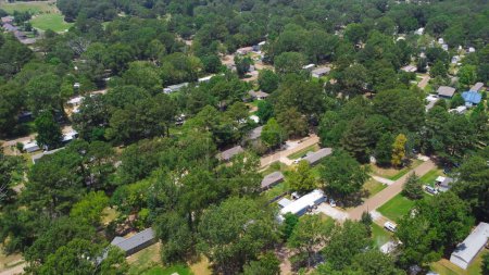 Photo for Low density housing of mobile manufactured homes surrounding by lush green trees near Richland Westside Park, suburb of Jackson, Mississippi, USA large lot size. Aerial view trailer neighborhood - Royalty Free Image