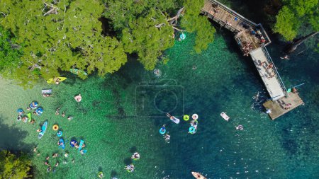 Plein de gens aiment flotter, nager, faire du kayak, sauter du pont, plonger dans l'eau turquoise bleue du Morrison Springs County Park, comté de Walton, Floride, États-Unis. Vue aérienne cyprès chauve luxuriant