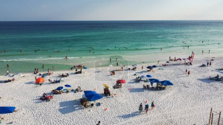 Téléchargez les photos : Tentes colorées, chaises longues de plage, verrière et foule de personnes nageant, se relaxant, marchant le long du rivage sablonneux blanc avec de l'eau turquoise, plage de South Walton, Destin, Floride. Destination de voyage - en image libre de droit