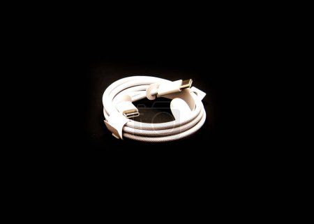 Foto de DALLAS, TX, US-OCT 28, 2023: El accesorio original de cable de carga USB-C viene con iPhone 15 Pro aislado sobre fondo negro, 15 son los primeros modelos de iPhone con el conector universal USB-C, USB-3 - Imagen libre de derechos
