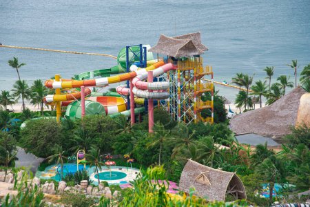 Téléchargez les photos : Close-up plage côté parc aquatique toboggans colorés tour tropical thème famille aquapark luxuriant cocotiers verts à Nha Trang, Vietnam. Destination de voyage - en image libre de droit