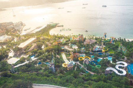 Photo for White sandy beach colorful water park tropical themed slide, splash pad, lazy river, playground, floating, ocean, obstacle course at Nha Trang bay, downtown skylines background, aerial view. Vietnam - Royalty Free Image