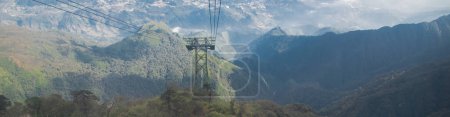 Téléchargez les photos : Panorama vue cadre en acier de l'ascenseur aérien pilier de téléphérique en pylône tiré télécabine ascenseur ou câble au-dessus du sol, Hoang Lien Son chaîne de montagnes luxuriante forêt verte, ciel bleu nuage ensoleillé, Sapa. Viêt Nam - en image libre de droit