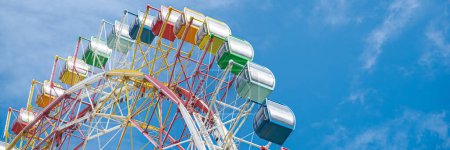 Photo for Panorama colorful sightseeing cabin or multiple passengers carrying components with support frame, rim of modern Ferris Wheel at amusement park in Nha Trang, Vietnam, blue sky, spoke cable. Travel - Royalty Free Image