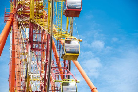 Detail of sightseeing cabin or multiple passengers carrying components on modern colorful Ferris Wheel with axle, rim, spoke cable, wheel turns upright by gravity, amusement park, Nha Trang. Vietnam