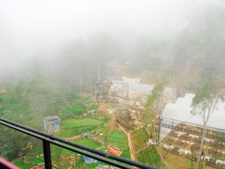 Foggy mountain landscape of Muong Hoa valley with green houses and backyard gardens vegetables, view from electric tramway light rail from Sapa to Muong Hoa Station cable car Fansipan travel. Vietnam
