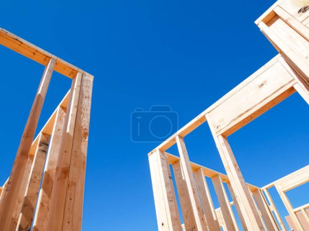 Door and windows opening on traditional timber framing house new build construction, joints, post, beam connection of medium size single family residential home in Dallas, Texas, clear blue sky. USA