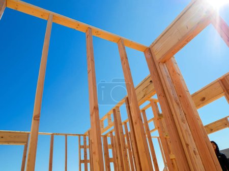 Framing of exterior, interior walls on traditional timber house new build construction, joints, post, beam connection of medium size single family residential home, Dallas, Texas, clear blue sky. USA
