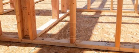 Panorama OSB sub flooring sheets cover, attach to the joists with wood screws Oriented Strand Board plywood, timber framing posts beams studs, new house construction, interior wall framing, Texas. USA