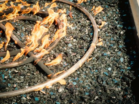 Téléchargez les photos : Fermez l'anneau de brûleur rond en acier inoxydable moderne avec orifices de brûleur percés à la machine pour une flamme constante du gaz naturel ou du propane, foyer extérieur avec verre noir, table de feu, Texas. États-Unis - en image libre de droit