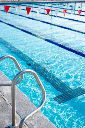 Handrail, Turning T marking under public competitive swimming pool, colorful string of polyester vinyl backstroke flags hanging over swimming lanes pool lane divider rope floats in Dallas, Texas. USA
