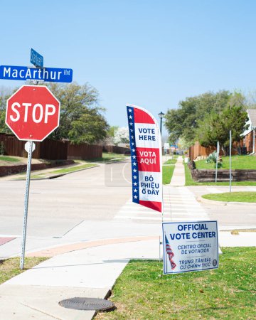 Photo for Street corner Stop and yard sign, vote banner flag show Official Vote Center in English, Spanish, Vietnamese welcome resident and non-English-proficient groups to voting location Dallas, Texas. USA - Royalty Free Image