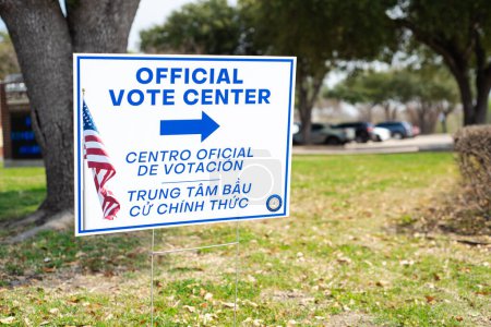 Photo for Official Vote Center yard sign with stake in English, Spanish, Vietnamese languages to welcome resident and non-English-proficient groups to voting location at elementary school in Dallas, Texas. USA - Royalty Free Image