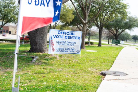 Photo for Yard sign and vote banner flag show Official Vote Center in English, Spanish, Vietnamese to welcome resident and non-English-proficient groups to voting location sidewalk pathway, Dallas, Texas. USA - Royalty Free Image