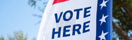 Photo for Panorama Vote Here high resolution text on political vote flag banner fiberglass poles, polyester double-sided election decorations polling locations on rotating pole, non-English-proficient, TX. USA - Royalty Free Image