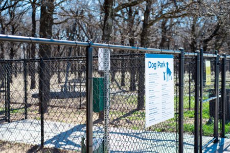 Gate entrance public dog park secured with galvanized vinyl-coated chain link fences, steel posts panels, concrete floor at rest area public picnic location along highway in Oklahoma, dog fencing. USA