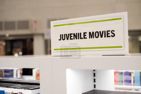 Colección de películas juveniles en estanterías muestra en la biblioteca pública de Texas, amplia variedad diversa de DVD, Blu-ray, CD, multimedia, contenido digital de visualización para el aprendizaje interactivo adolescente. Estados Unidos