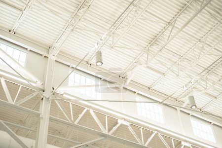 Edificio de estilo almacén alto con grandes ventanas para luz natural y luces led de haz de techo moderno, estructura de techo de metal suspendido, edificio de fábrica de la industria de almacenes de acero, Texas. Estados Unidos