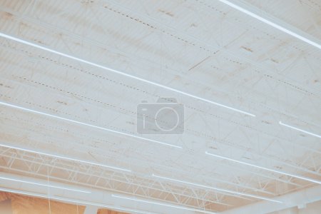 Lange Geschäft LED-Leuchten hängen über modernen abgehängten Decke Metalldachkonstruktion, Lagerindustrie Fabrik Gebäude Beleuchtungslösung Hintergrund, Perimeter Track Membran Fachwerk, Frisco, TX. USA