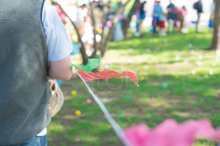 Shallow DOF long line of diverse parents kids near pennant tape barricada line waiting for Easter egg hunting tradition at local Church in Dallas, Texas, decorated Paschal on green grass meadow. Estados Unidos