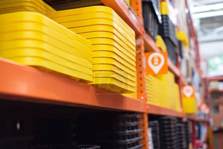 Pila de tapa reforzada de polipropileno reciclado amarillo para asegurar almacenamiento de servicio pesado, solución de contenedores de caja de organización para el hogar en la tienda de mejoras para el hogar de hardware, Dallas, Texas. Estados Unidos