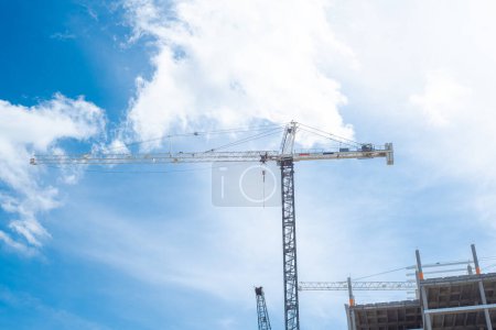 Looking up view working cranes at construction site of high-rise hotels, office building, skyscraper, unfinished commercial real estate development, downtown Irving, Texas, industrial background. USA