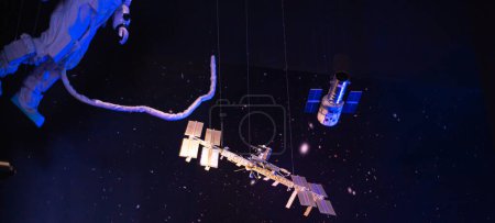 Téléchargez les photos : Astronaute Panorama avec sécurité cordon ombilical attache sortie dans l'espace promenade autour de la Station spatiale internationale, structure de treillis intégré, orbite Terre et galaxie suspendue au plafond du musée au Texas. États-Unis - en image libre de droit