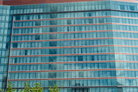 Nahaufnahme modernes Hochhaushotel mit Verdunkelungsvorhängen aus Glas vor sonnigem wolkenblauem Himmel in Texas, Blick auf Bürogebäude, Wolkenkratzer, futuristisch anmutende Architektur. USA