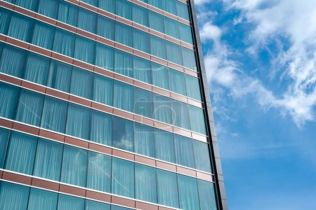 Wolkenreflexion an der Glaswand eines modernen Hotelhochhauses mit Verdunkelungsvorhängen in Texas, Blick auf Bürogebäude, Wolkenkratzer, futuristisch anmutende Architektur. USA