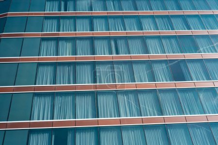 Nahaufnahme modernes Hochhaushotel mit Verdunkelungsvorhängen aus Glas vor sonnigem wolkenblauem Himmel in Texas, Blick auf Bürogebäude, Wolkenkratzer, futuristisch anmutende Architektur. USA