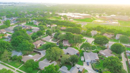 Aerial view suburban residential neighborhood with cul-de-sac dead-end keyhole street, lush greenery trees, middle elementary school complex football track field, playground, North Texas, Dallas. USA