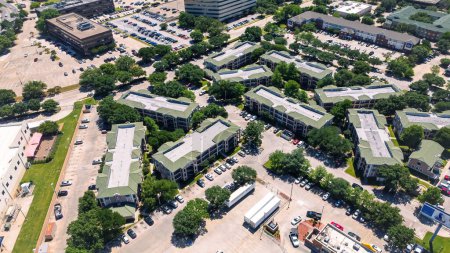 Top view dense of office buildings, hotels, restaurants with ample parking spaces in urbanized zones Northwest Dallas business park, Love Field neighborhood, lush green tree cover, aerial view. USA