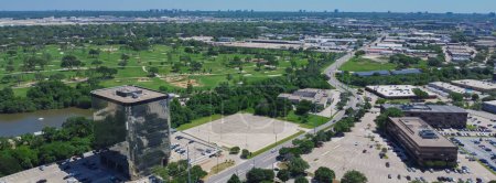 Panorama aerial view urbanized zones, business park in Northwest Dallas with downtown Irving, Denton in distant background, group of office buildings, hotels, restaurants with ample parking space. USA