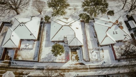 Toned photo residential streets and row of single-family houses covered in snow after severe weather, climate change event in Dallas-Fort Worth metropolitan subdivision, sunshine melting, aerial. USA