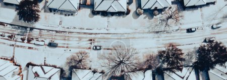 Vista panorámica fila de casas unifamiliares cubiertas de nieve pesada en techos de tejas, residencial calle suburbana Dallas-Fort Worth metropolitana, clima severo, cambio climático, sol derretimiento. Estados Unidos