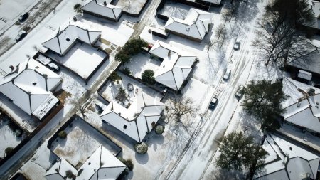 Getönte Foto-Wohnstraßen und Einfamilienhausreihen, die nach schweren Unwettern mit Schnee bedeckt sind, Klimaereignis im Großraum Dallas-Fort Worth, Sonnenscheinschmelze, Antenne. USA