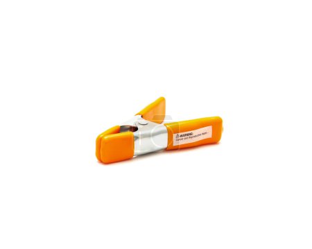 Top view spring clamp with orange poly vinyl protected handles and jaw tips contours non-slip isolated on white background, heavy duty tempered steel allows instant opening, closing. Clipping path