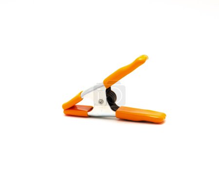 Rear view nickel plated steel spring clamp with orange poly vinyl protected handles and jaw tips contours non-slip isolated on white background, clamp tool instant opening and closing. Clipping path