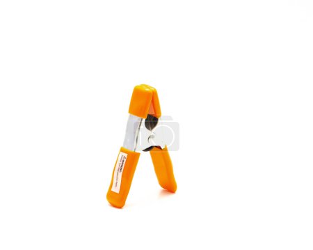 Orange poly vinyl protected handles and jaw tips contours non-slip of spring clamp made of heavy-duty tempered steel allows instant opening and closing isolated on white background. Copy space